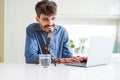 Young hipster man recording podcast using laptop, broadcasting an interview using microphone Royalty Free Stock Photo