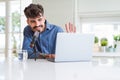 Young hipster man recording podcast using laptop, broadcasting an interview using microphone Royalty Free Stock Photo