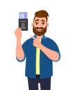 Young hipster man showing passport tickets and pointing finger. Trendy person holding boarding pass. Travel and tourism concept.