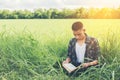 Young hipster man sitting on grassland reading book with nature Royalty Free Stock Photo