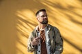 Young hipster millennial man standing on the street waiting for woman he met online on online dating site or social network. Royalty Free Stock Photo