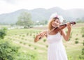 Young hipster musician woman playing violin in the nature outdoor lifestyle behind mountain Royalty Free Stock Photo