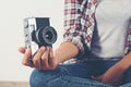 Young hipster photographer hand holding retro camera sitting on Royalty Free Stock Photo