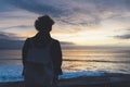 Young hipster relax on the beach on background ocean sunrise, silhouette romantic person looking view evening seascape, girl enjoy Royalty Free Stock Photo