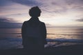 Young hipster relax on the beach on background ocean sunrise, silhouette romantic person looking view evening seascape, girl enjoy Royalty Free Stock Photo