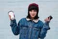 Young hipster smiling girl holding phone and coffee Royalty Free Stock Photo