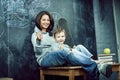 Young hipster teenage girl sitting with her little brother in classroom multinational, lifestyle people concept Royalty Free Stock Photo