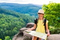 Young hipster tourist girl holding and looking map on trip; life