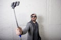 Young hipster trendy blogger man holding stick recording selfie video in vlog concept Royalty Free Stock Photo