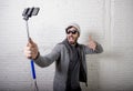 Young hipster trendy blogger man holding stick recording selfie video in vlog concept Royalty Free Stock Photo