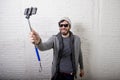 Young hipster trendy blogger man holding stick recording selfie video in vlog concept Royalty Free Stock Photo