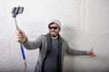 Young hipster trendy blogger man holding stick recording selfie video in vlog concept Royalty Free Stock Photo