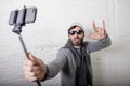 Young hipster trendy blogger man holding stick recording selfie video in vlog concept Royalty Free Stock Photo