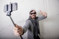 Young hipster trendy blogger man holding stick recording selfie video in vlog concept Royalty Free Stock Photo