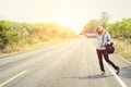 Young hipster woman hitchhiking on countryside road wait for the Royalty Free Stock Photo