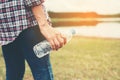 young hipster woman holding bottle of water at summer green park