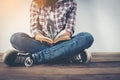 Young hipster woman holding open book sitting on wooden floor. Royalty Free Stock Photo