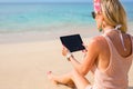 Young woman holding tablet on the beach Royalty Free Stock Photo