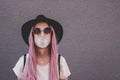 Young hipster woman with long pink hair blowing a bubble with bubble gum. Royalty Free Stock Photo