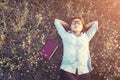 Young hipster woman lying in flower field after she tired for re Royalty Free Stock Photo