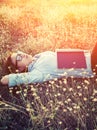 Young hipster woman lying in flower field after she tired for re Royalty Free Stock Photo