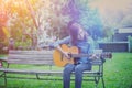 Close up of young hipster woman practiced guitar in the park,happy and enjoy playing guitar Royalty Free Stock Photo