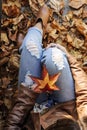 Young hipster woman is sitting among autumn leaves. Royalty Free Stock Photo