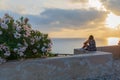 Young hipster woman traveler looking at sunset and beautiful seascape in summer vacation with a lookout point Royalty Free Stock Photo