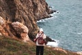 A young hipster woman walks on the rocks near the sea. Winter travel to coastal countries. Crimea, Balaclava