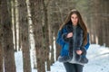 Young hipster woman in winter forest having fun with snow