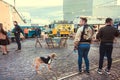 Young hipsters walking around urban area of city with fast food court and outdoor restaurants