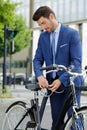 young businessman attaching bike