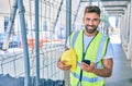 Young hispanic architect man holding blueprint using smartphone at street of city Royalty Free Stock Photo