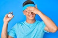 Young hispanic boy holding stopwatch stressed and frustrated with hand on head, surprised and angry face Royalty Free Stock Photo