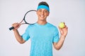 Young hispanic boy playing tennis holding racket and ball smiling with a happy and cool smile on face Royalty Free Stock Photo