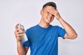 Young hispanic boy using hand sanitizer gel stressed and frustrated with hand on head, surprised and angry face Royalty Free Stock Photo