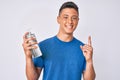 Young hispanic boy using hand sanitizer gel surprised with an idea or question pointing finger with happy face, number one Royalty Free Stock Photo