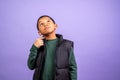 young hispanic boy wearing black vest and green shirt is looking up at the camera Royalty Free Stock Photo