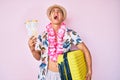 Young hispanic boy wearing summer style holding cabin suitcase and boarding tickets angry and mad screaming frustrated and Royalty Free Stock Photo