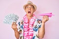 Young hispanic boy wearing summer style holding dollars and paper airplane angry and mad screaming frustrated and furious, Royalty Free Stock Photo