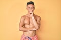 Young hispanic boy wearing swimwear shirtless thinking looking tired and bored with depression problems with crossed arms Royalty Free Stock Photo