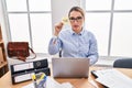 Young hispanic business woman at the office calculating taxes thinking attitude and sober expression looking self confident Royalty Free Stock Photo