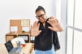 Young hispanic business woman working at the office afraid and terrified with fear expression stop gesture with hands, shouting in Royalty Free Stock Photo