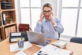 Young hispanic business woman working at the office talking on two phones clueless and confused expression Royalty Free Stock Photo