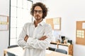 Young hispanic businessman with serious expression standing with arms crossed gesture at office Royalty Free Stock Photo