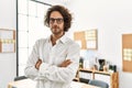 Young hispanic businessman with serious expression standing with arms crossed gesture at office Royalty Free Stock Photo