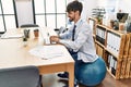 Young hispanic businessman sitting on fit ball working at the office Royalty Free Stock Photo