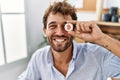 Young hispanic businessman smiling happy holding bitcoin over eye at the office Royalty Free Stock Photo