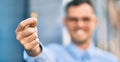 Young hispanic businessman smiling happy holding 1 euro coin at the city Royalty Free Stock Photo