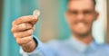 Young hispanic businessman smiling happy holding 1 euro coin at the city Royalty Free Stock Photo